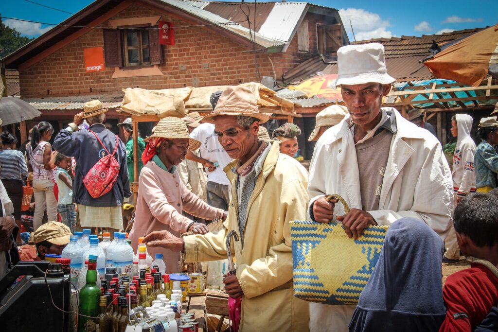 Marché local dans un village des hauts plateaux de Madagascar. Des sexagénaires avec des chapeaux divers tenant des paniers artisanaux tressés